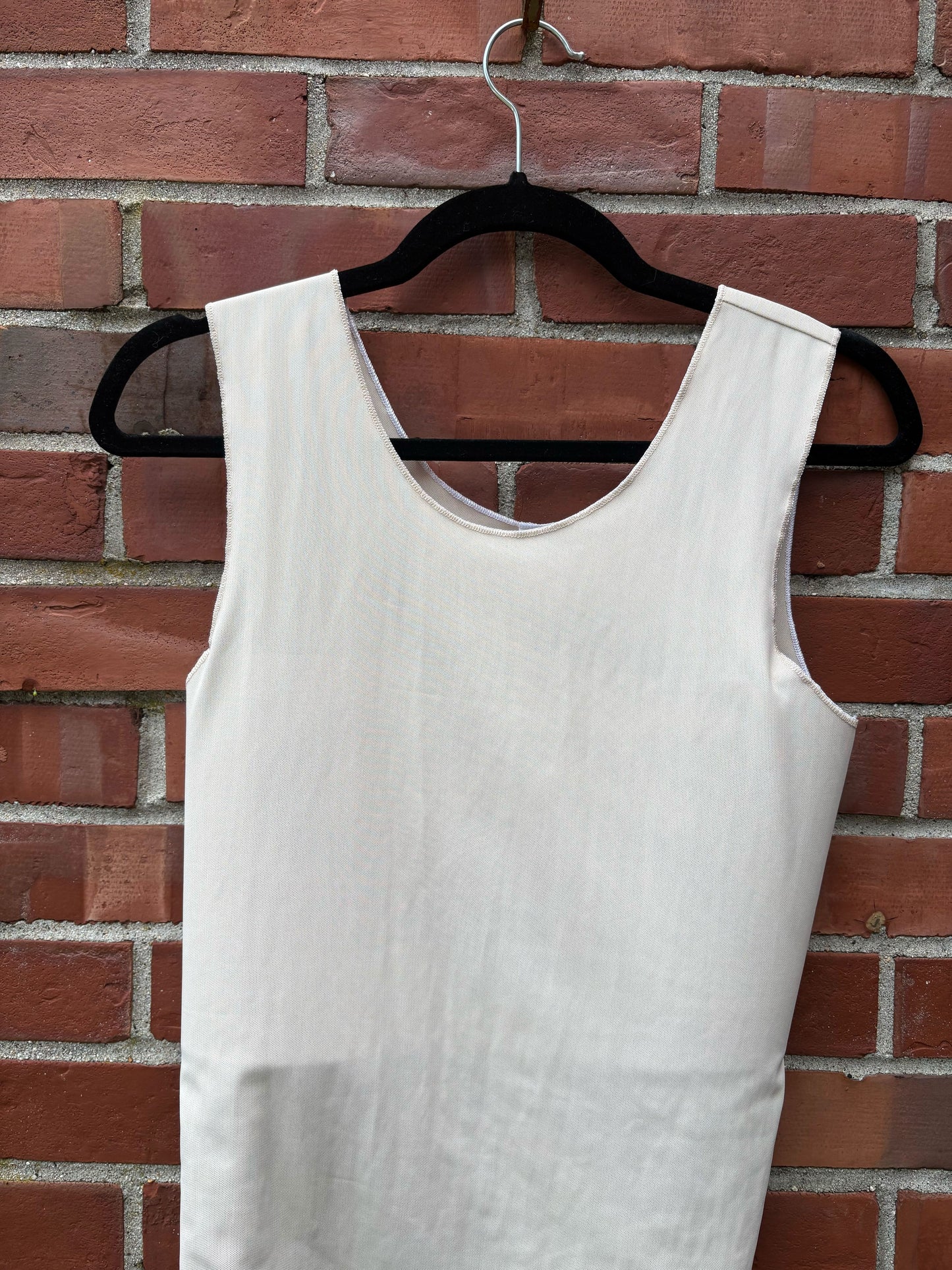 Aspen mesh binder on a hanger against a brick wall.