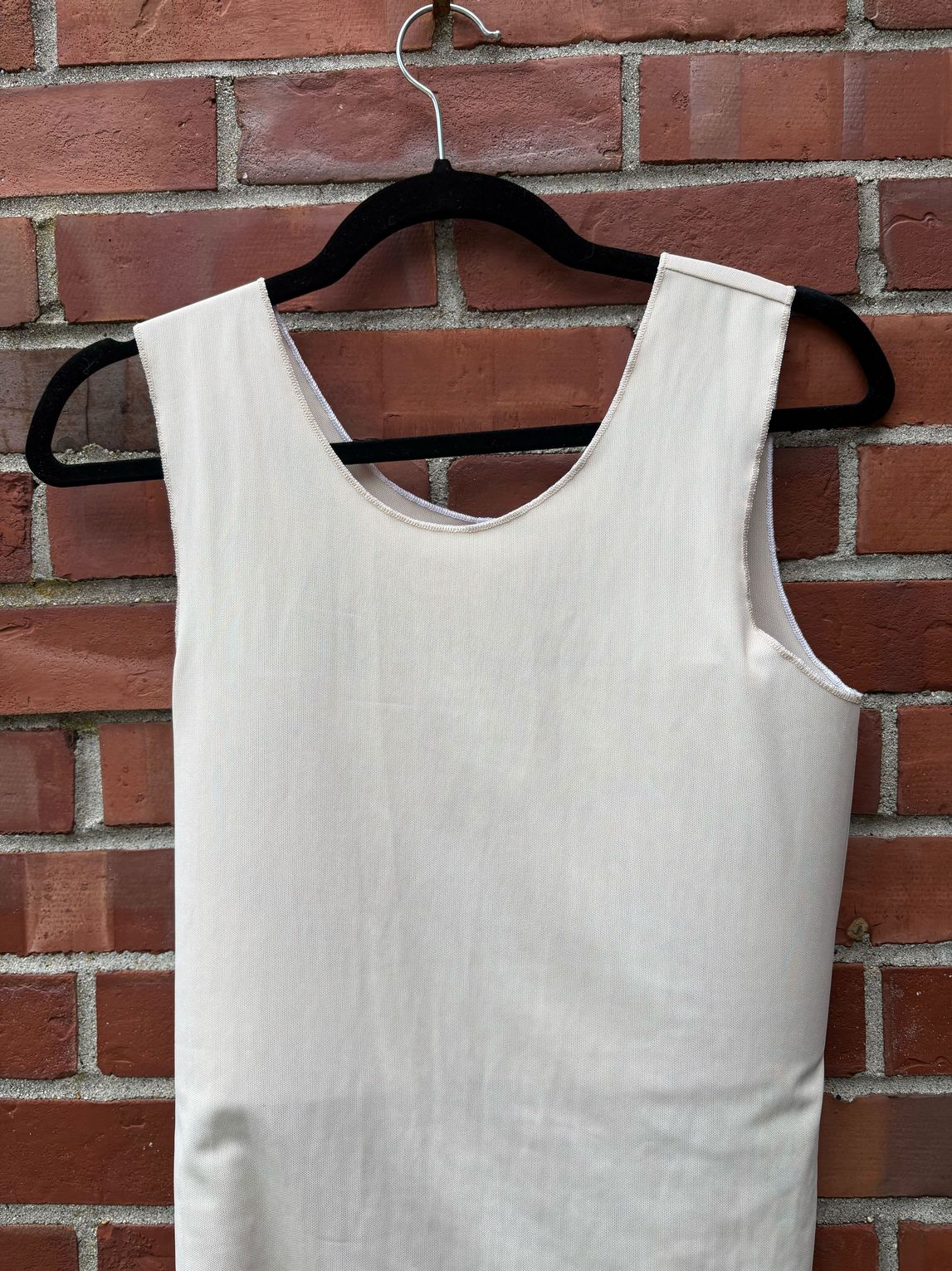 Aspen mesh binder on a hanger against a brick wall.